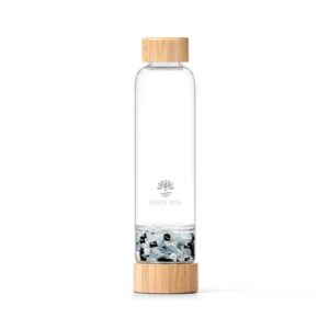 Eine elegante Glas-Trinkflasche mit Bambusdeckel und einem separaten Bodenfach, gefüllt mit einer Mischung aus bläulichen und schwarzen Edelsteinen.